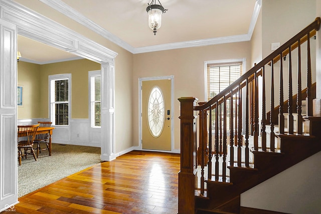 entrance foyer with crown molding and light hardwood / wood-style floors