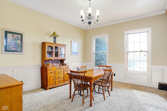 dining room featuring crown molding, light colored carpet, and a notable chandelier