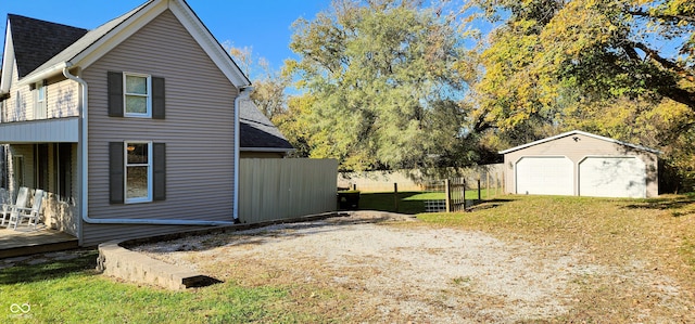 view of side of home with a yard, an outbuilding, and a garage