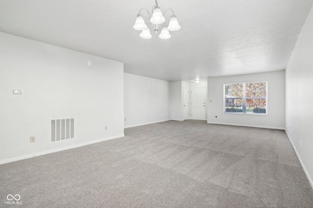 empty room with a notable chandelier and carpet flooring