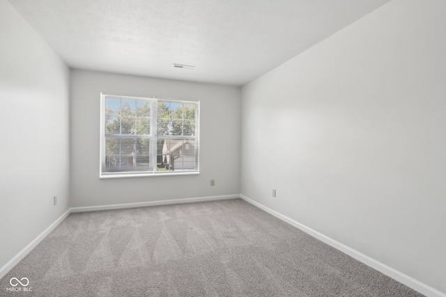 spare room featuring light colored carpet