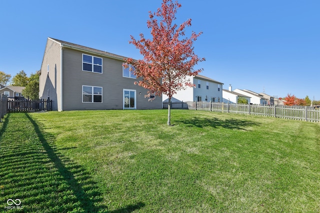 rear view of property featuring a lawn