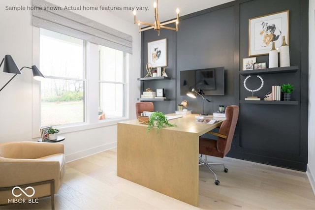 office with light hardwood / wood-style floors and an inviting chandelier