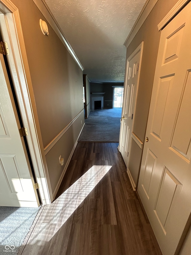 hall featuring dark hardwood / wood-style floors and a textured ceiling