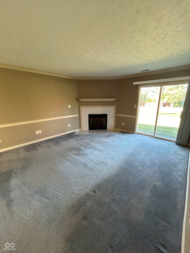 unfurnished living room featuring carpet flooring, a textured ceiling, a tile fireplace, and ornamental molding