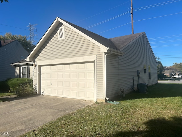 view of side of property with central air condition unit, a yard, and a garage