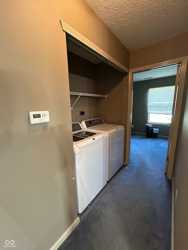 clothes washing area featuring independent washer and dryer, a textured ceiling, and dark carpet