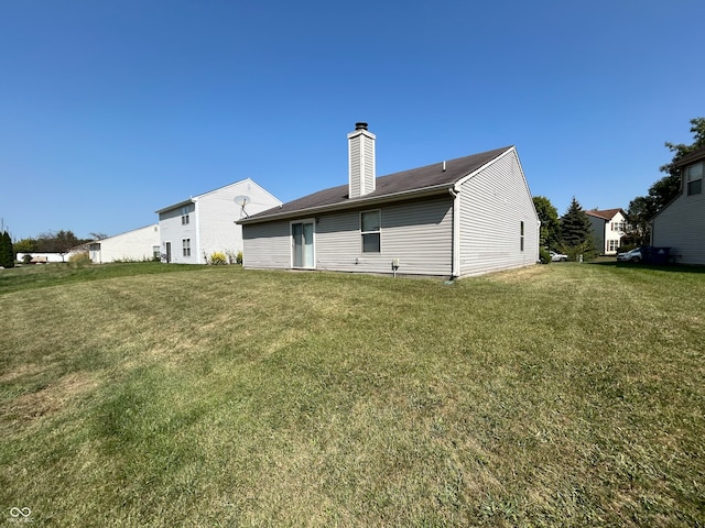 back of house featuring a lawn