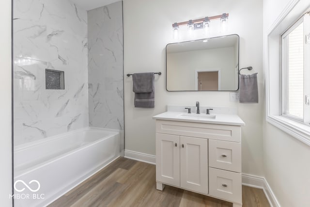 bathroom featuring tiled shower / bath combo, vanity, hardwood / wood-style floors, and a healthy amount of sunlight