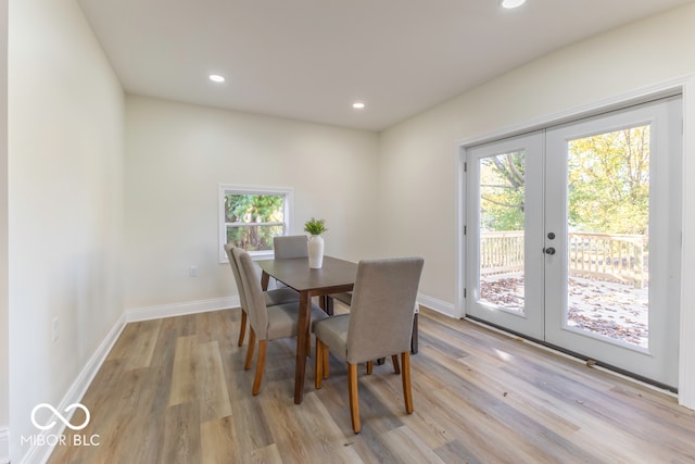 dining room with french doors, a wealth of natural light, and light hardwood / wood-style flooring