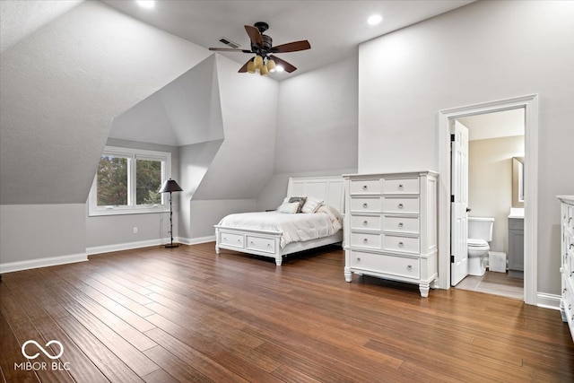 unfurnished bedroom featuring dark hardwood / wood-style floors, ensuite bath, vaulted ceiling, and ceiling fan