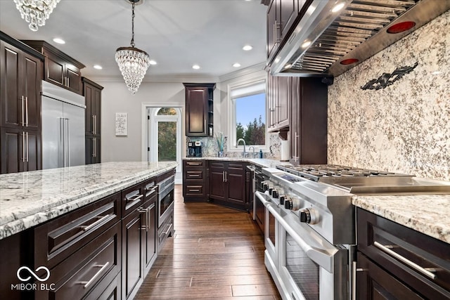 kitchen featuring wall chimney range hood, high quality appliances, dark brown cabinets, pendant lighting, and dark wood-type flooring