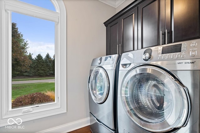 laundry area featuring cabinets, a wealth of natural light, and washer and clothes dryer