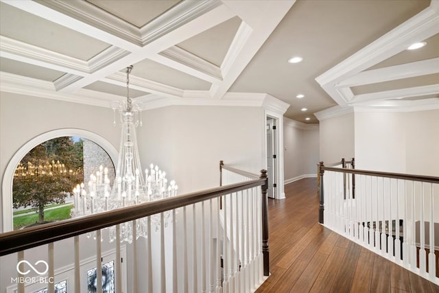 hallway featuring beam ceiling, an inviting chandelier, ornamental molding, dark wood-type flooring, and coffered ceiling