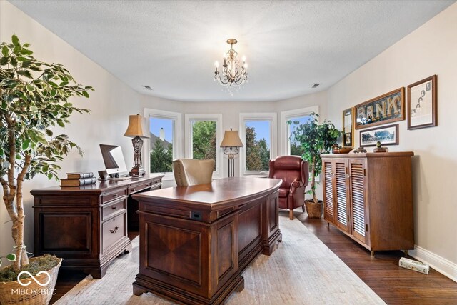 office featuring a notable chandelier, hardwood / wood-style flooring, and a textured ceiling