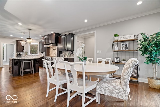 dining area with ornamental molding, dark hardwood / wood-style floors, and sink