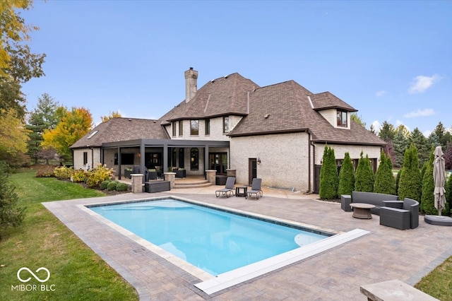 rear view of property featuring a yard, an outdoor living space, and a patio area