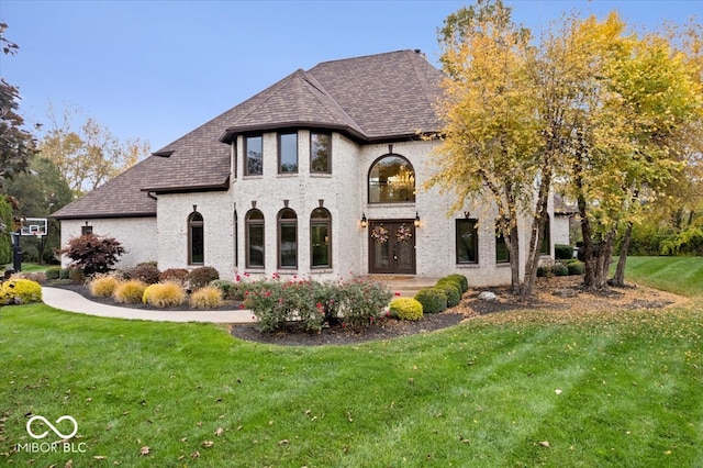 rear view of property with french doors and a yard