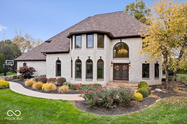 back of house featuring french doors and a lawn