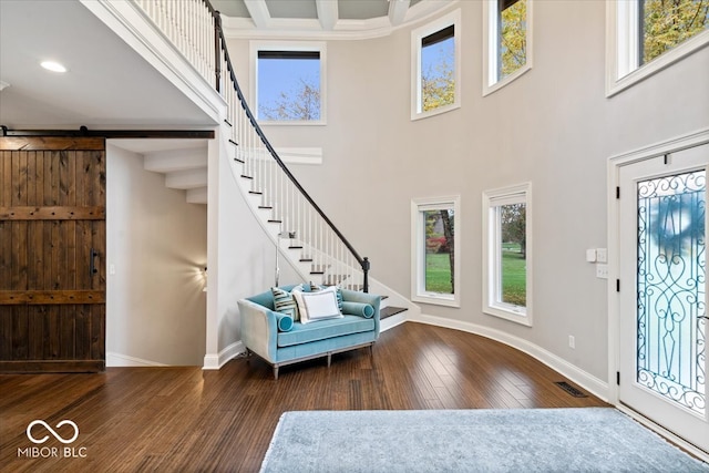 entrance foyer with dark wood-type flooring, plenty of natural light, and a barn door