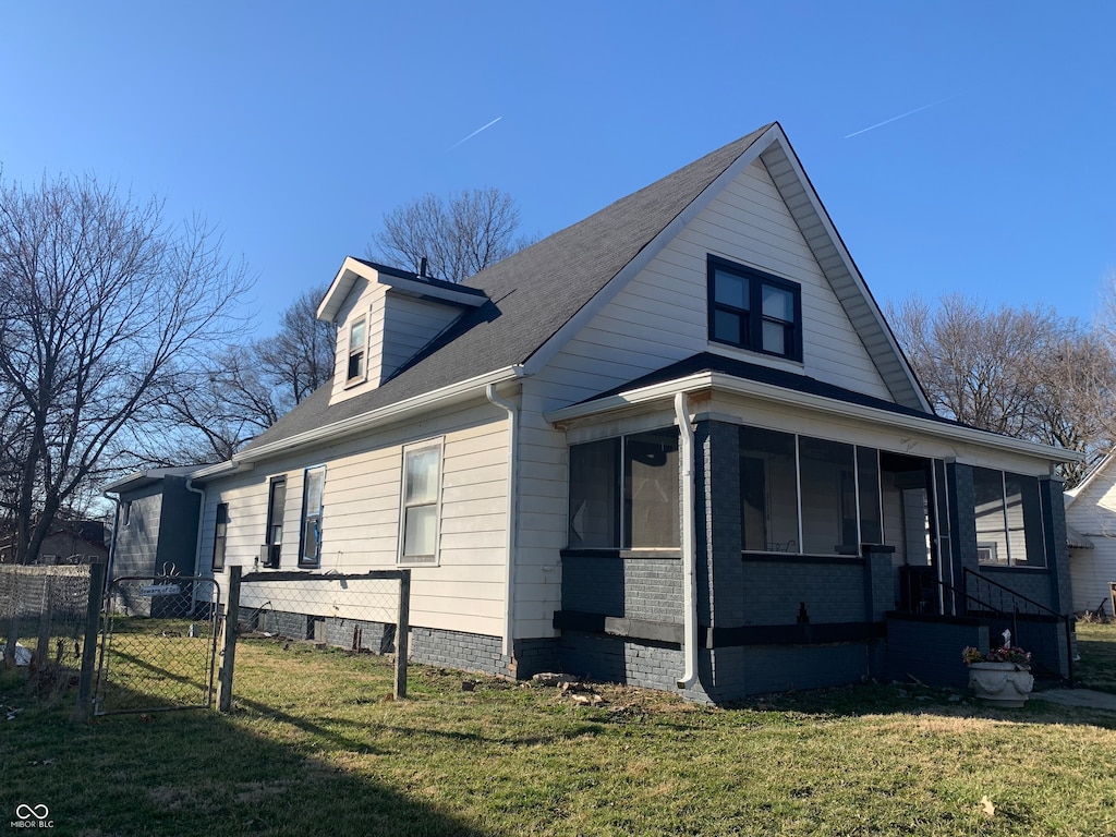 view of side of property with a yard and a sunroom