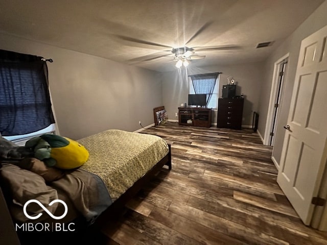 bedroom with dark hardwood / wood-style flooring and ceiling fan