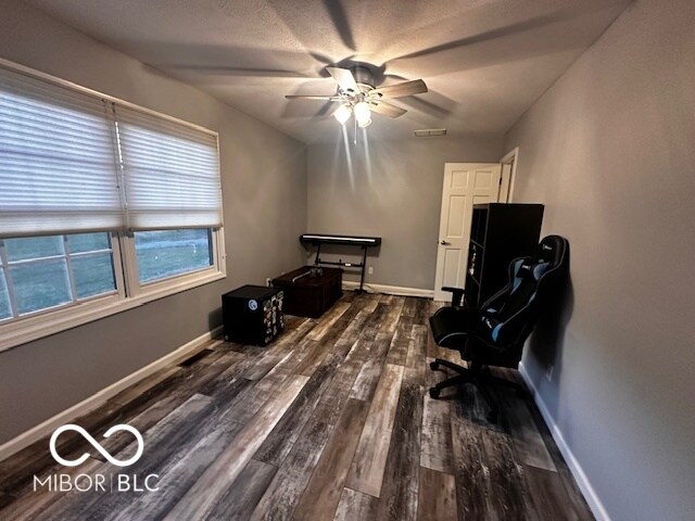 office area with ceiling fan and dark hardwood / wood-style flooring