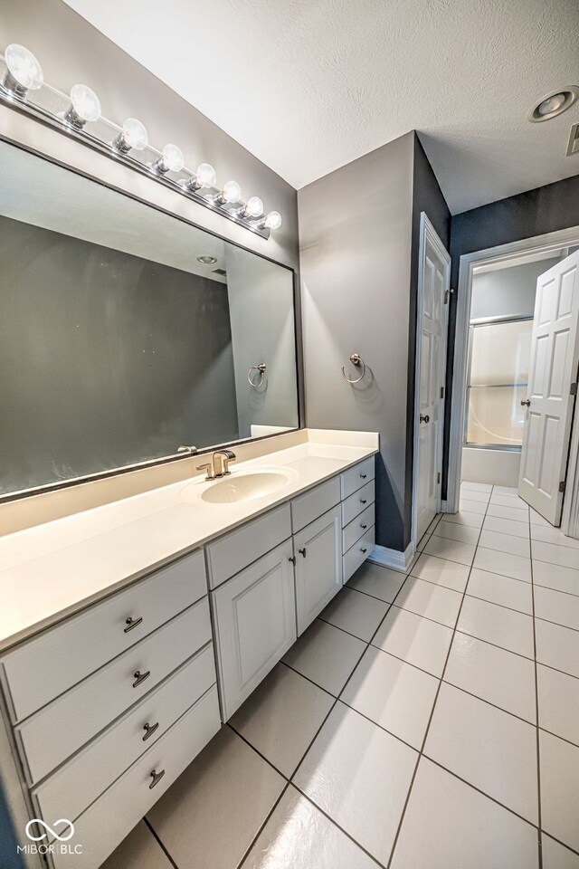 bathroom with vanity, a textured ceiling, tile patterned floors, and tub / shower combination