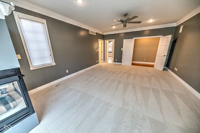 unfurnished bedroom with ceiling fan, light carpet, and crown molding