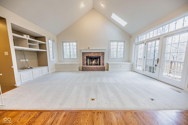 808 Copperfield Xing, Danville, IN 46122 - unfurnished living room with high vaulted ceiling, a skylight, a fireplace, built in shelves, and baseboards