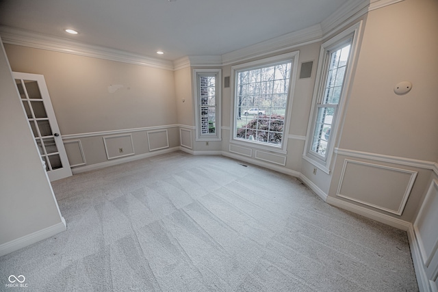 empty room with light colored carpet and crown molding