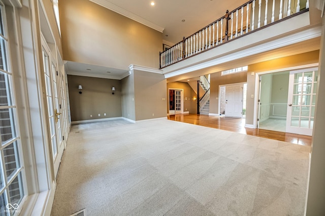 808 Copperfield Xing, Danville, IN 46122 - unfurnished living room with french doors, carpet flooring, a high ceiling, baseboards, and crown molding