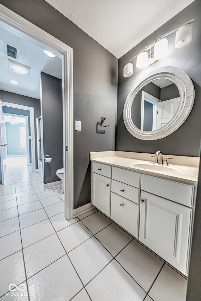 bathroom with toilet, vanity, a textured ceiling, and tile patterned floors