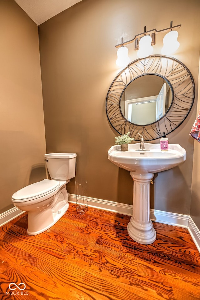 bathroom with toilet and hardwood / wood-style floors