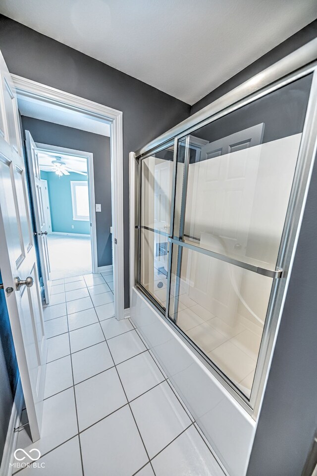 bathroom with ceiling fan, tile patterned floors, and combined bath / shower with glass door