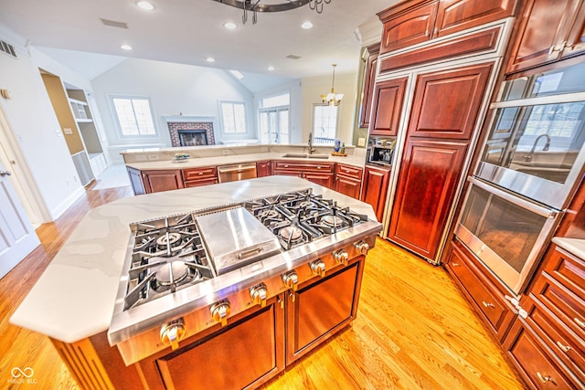808 Copperfield Xing, Danville, IN 46122 - kitchen with dishwasher, a chandelier, light wood-type flooring, a peninsula, and a fireplace