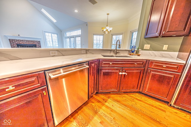 kitchen with sink, vaulted ceiling with skylight, a notable chandelier, light wood-type flooring, and dishwasher