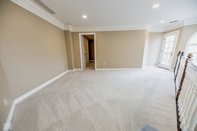 spare room featuring light colored carpet and crown molding