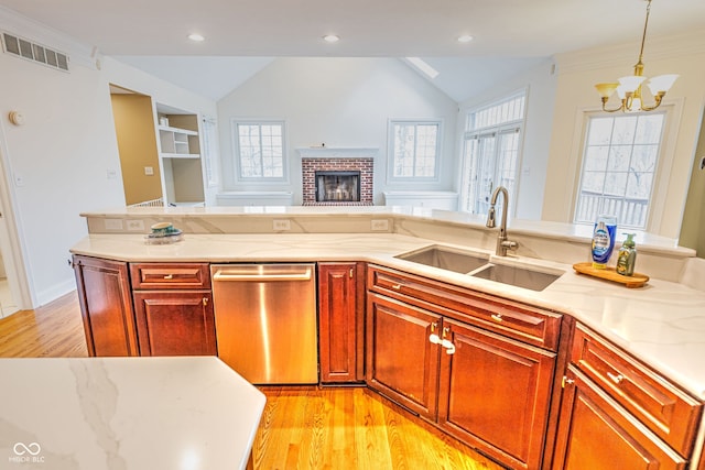 kitchen featuring decorative light fixtures, sink, vaulted ceiling, dishwasher, and light hardwood / wood-style flooring