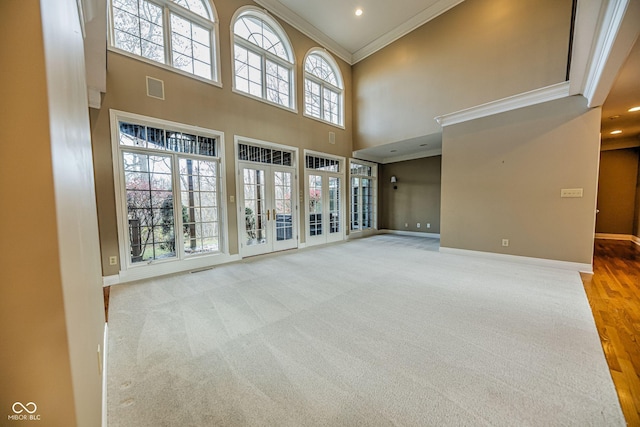 808 Copperfield Xing, Danville, IN 46122 - unfurnished living room featuring ornamental molding, baseboards, a towering ceiling, french doors, and carpet