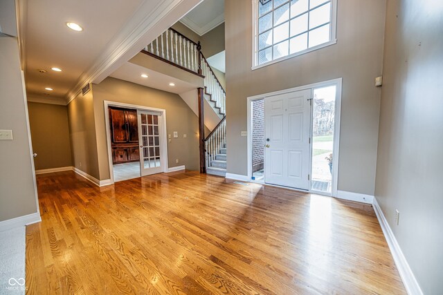 foyer entrance with ornamental molding and light hardwood / wood-style flooring