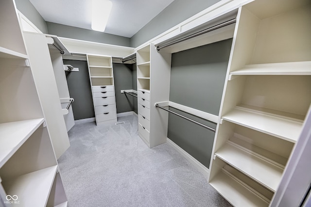 walk in closet featuring light carpet