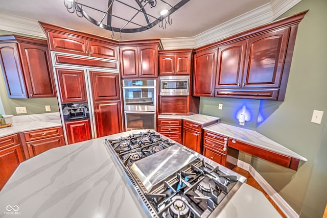 kitchen with light stone counters, built in appliances, and crown molding