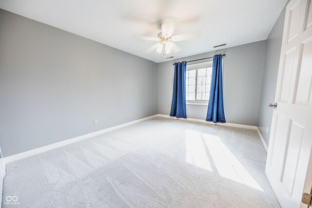 carpeted spare room featuring ceiling fan