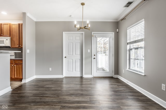 unfurnished dining area featuring dark hardwood / wood-style flooring, a chandelier, and crown molding