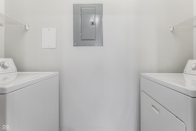 clothes washing area featuring electric panel and washing machine and dryer