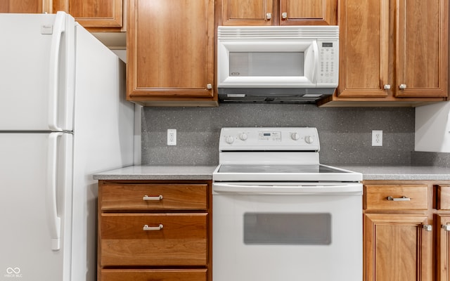 kitchen with backsplash and white appliances