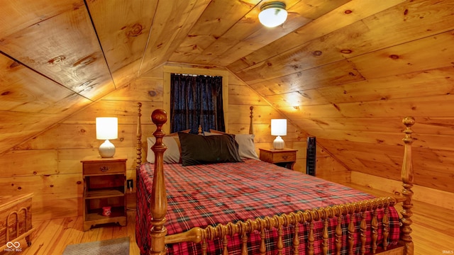 bedroom with lofted ceiling, hardwood / wood-style floors, wooden ceiling, and wooden walls