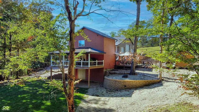 rear view of property featuring a yard and a deck