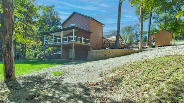 exterior space with a wooden deck, a yard, and a shed